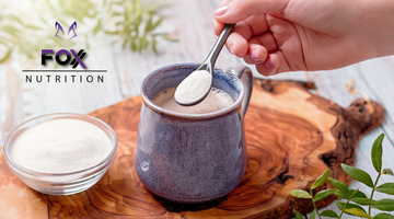 Image of a small bowl of collagen powder next to a mug of coffee with a spoon with a healthy scoop of collagen powder over the mug 